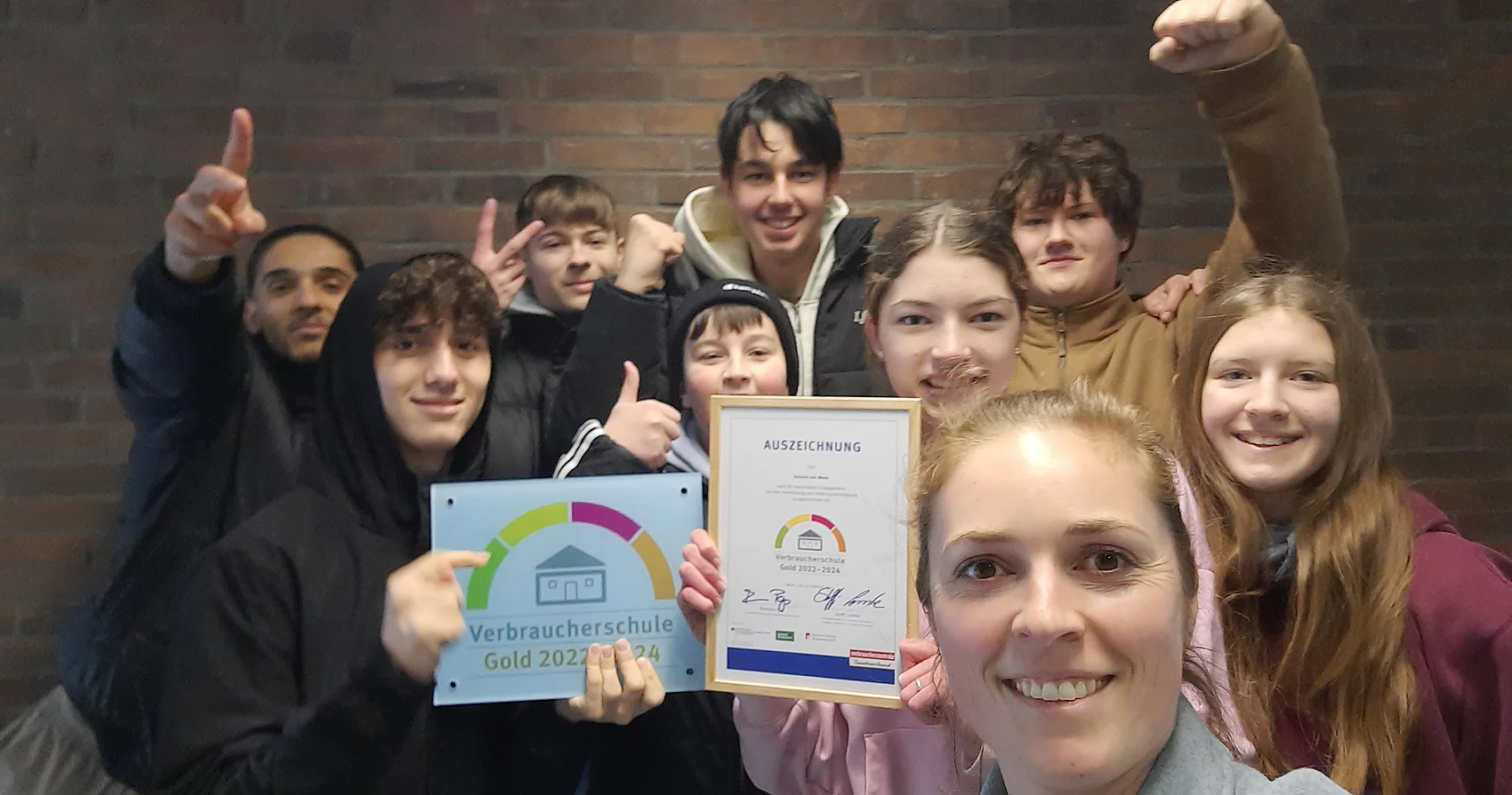 Schule am Meer hat Auszeichnung als Verbraucherschule GOLD. Gruppenbild mit Schülern und Lehrerin Alexandra Colmsee. Präsentation der Urkunde.