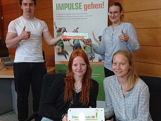 Schülerinnen und Schüler präsentieren die AUszeichnung zur Zukunftsschule.
