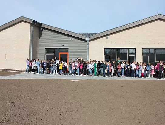 Einweihung neue Grundschule Büsum. Einweihungsfeier. Außenansicht. Grundschüler und Kollegium warten auf Beginn.