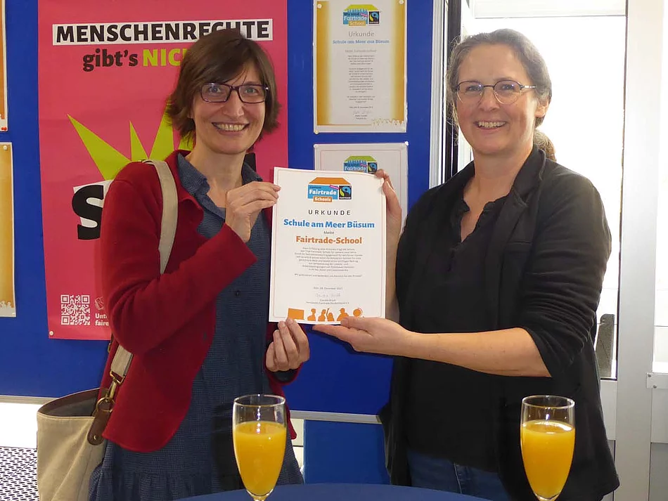 Eine Welt-Promotorin Antje Edler (links) überreicht der AG-Leiterin Britta Baar die Auszeichnung als Fairtrade School.