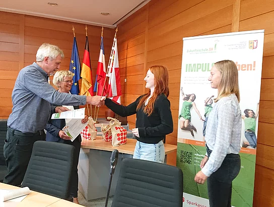 Schülerinnen der SaM nehmen die Auszeichnung zur Zukunftsschule entgegen.