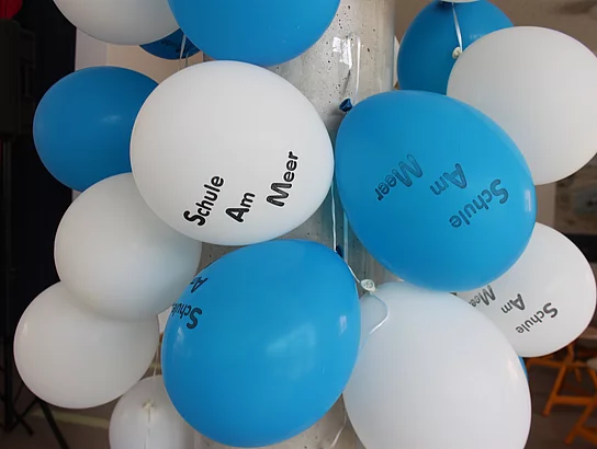 Einweihung neue Grundschule Büsum. Einweihungsfeier. Innenansicht. Aula. Blaue und weiße Luftballons mit Aufdruck "Schule am Meer". Dekoration.